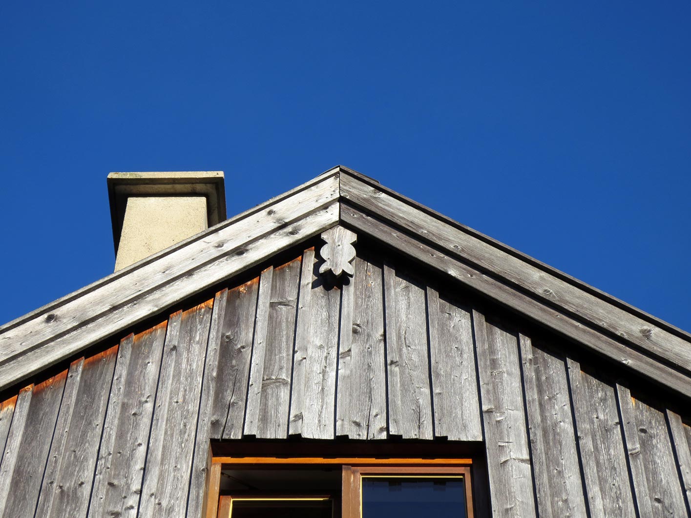 Vergraute Holzfassade eines Hauses mit silbergrauer Oberfläche